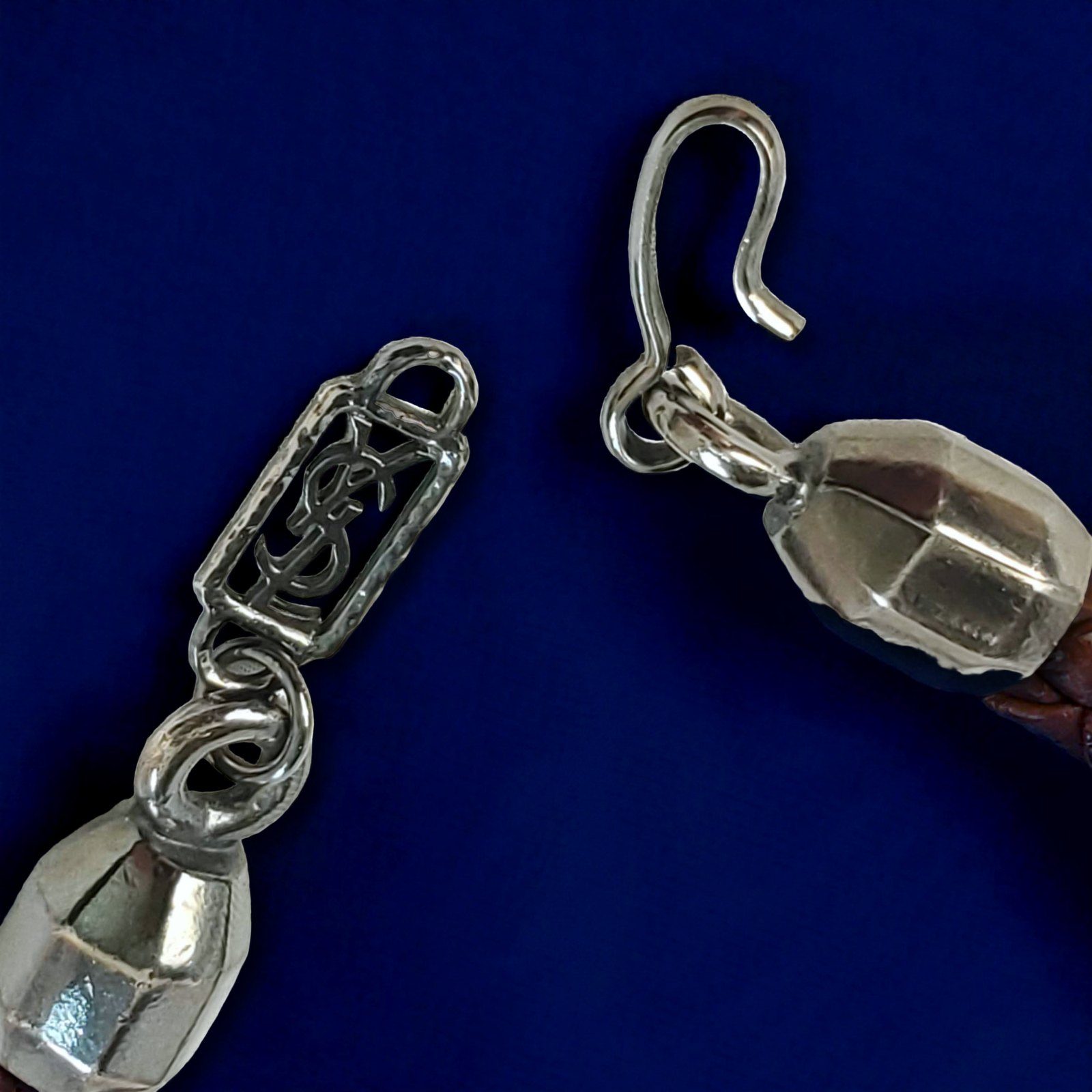 The hook clasp and the pierced YSL logo plaque on the cord.